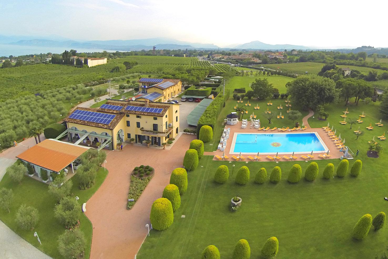 Vista aerea del Relais del Sol tra il parco, la piscina e il Lago di Garda